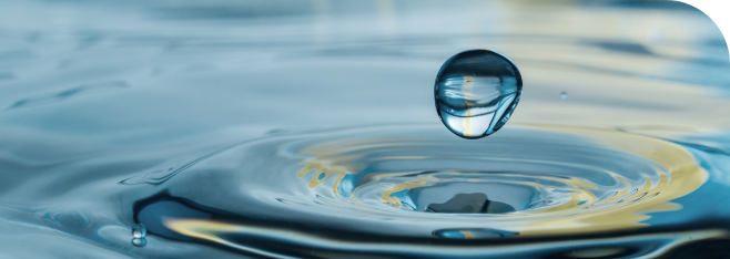 Water droplet suspended above a calm surface, symbolizing Rainmaker’s Air-to-Water technology for generating clean drinking water from air